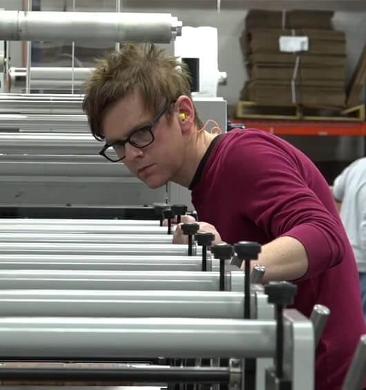 An Apogee employee examines printing equipment