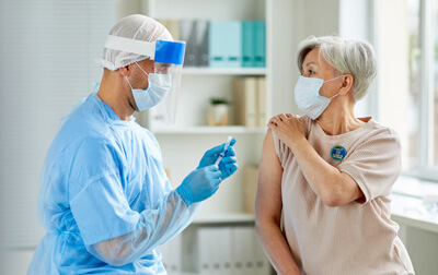 Woman receving vaccination with vaccination sticker